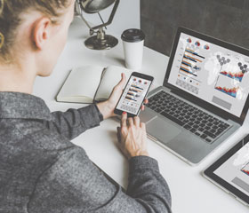 Persona viendo los mismo datos en un ordenador, móvil y tablet